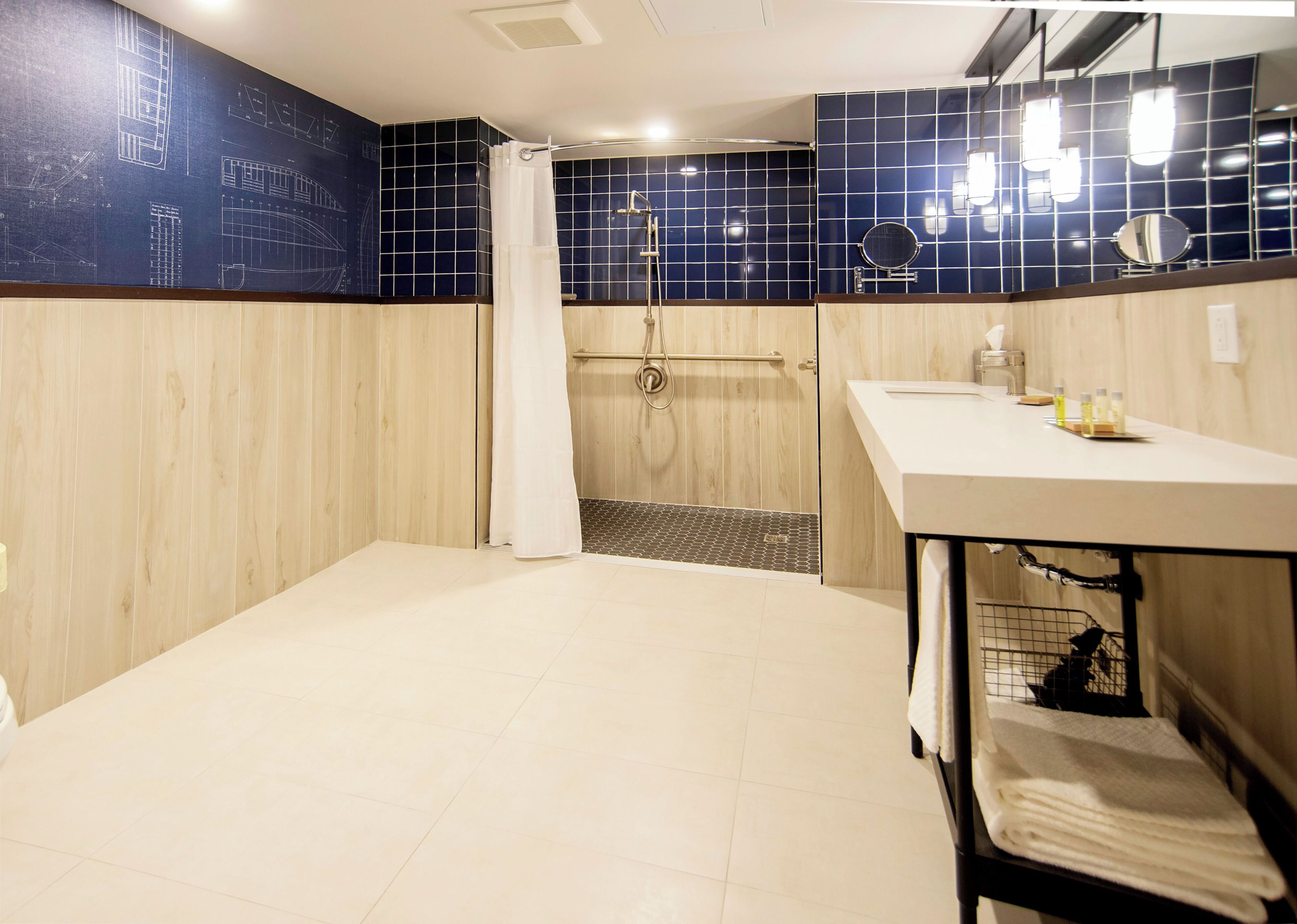 A bathroom with a shower, a sink, and a mirror.