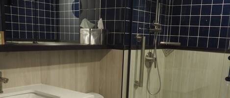 A modern bathroom with a white sink, toilet, and shower.