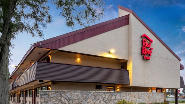 A Red Roof Inn with a stone facade, a balcony, and a parking lot. - Red Roof Inn Mt Laurel (Mount Laurel)