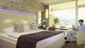 Une chambre d’hôtel avec un grand lit, un bureau et une vue sur l’extérieur.