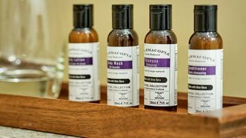 Four bottles of skincare products on a wooden tray.