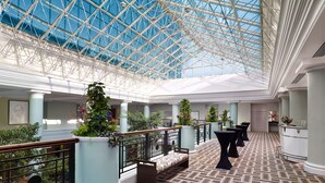 A spacious atrium with a high glass ceiling, columns, and seating areas. - Hyatt Regency Birmingham (Birmingham)