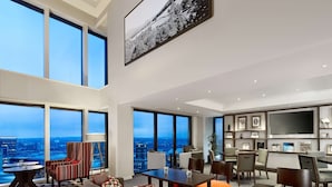 A spacious living area with large windows, a modern sofa, and a dining table. - Hyatt Regency Birmingham (Birmingham)