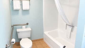 A bathroom with a toilet, a shower with a curtain, and two towels on a rack.