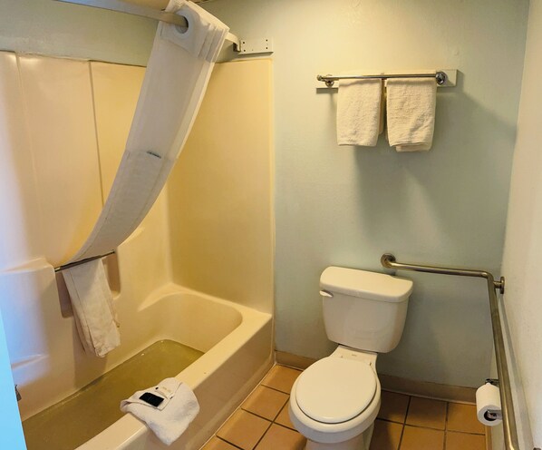Un baño con bañera, inodoro y toallero.
