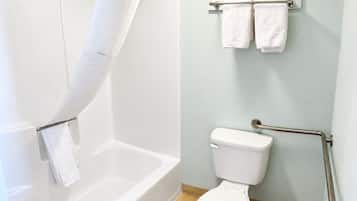 A bathroom with a bathtub, toilet, and towel rack.