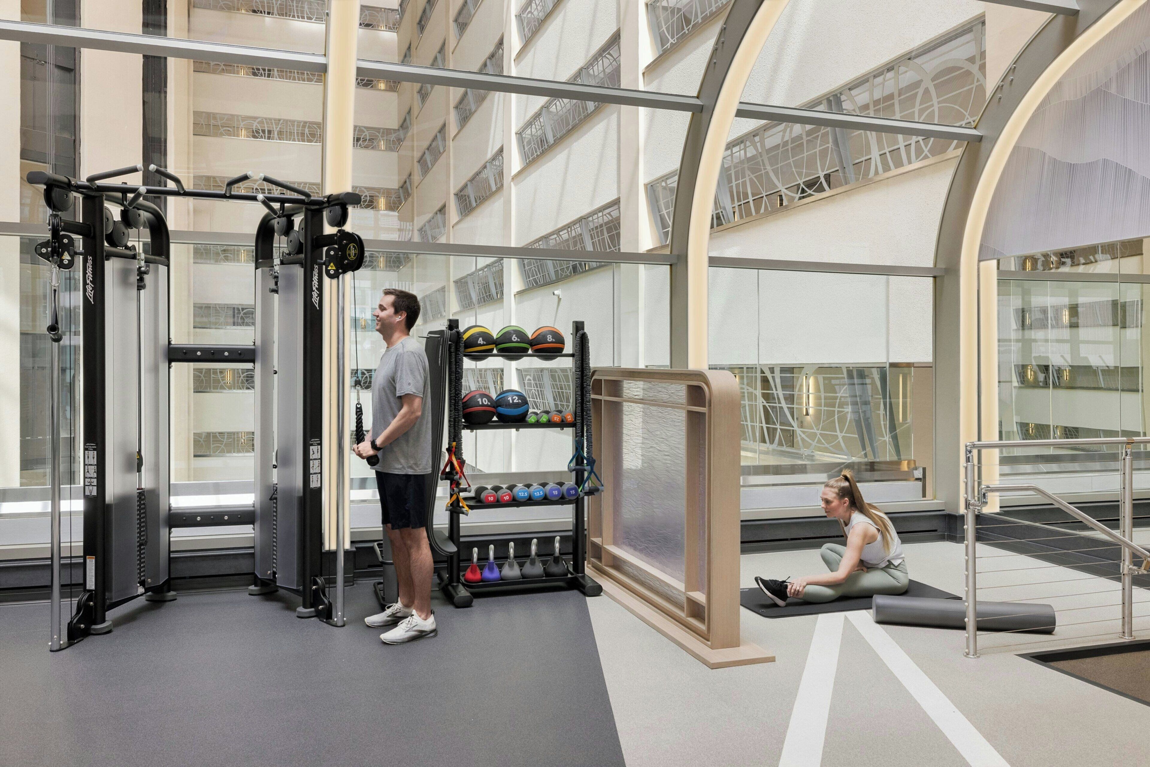 A gym with weightlifting equipment, a squat rack, and a bench.