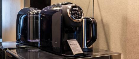 A coffee machine with a digital display and a tag on a metallic counter.