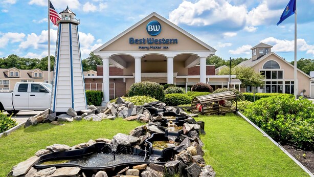 A Best Western hotel with a prominent lighthouse-like structure, a swimming pool, and a well-maintained lawn.