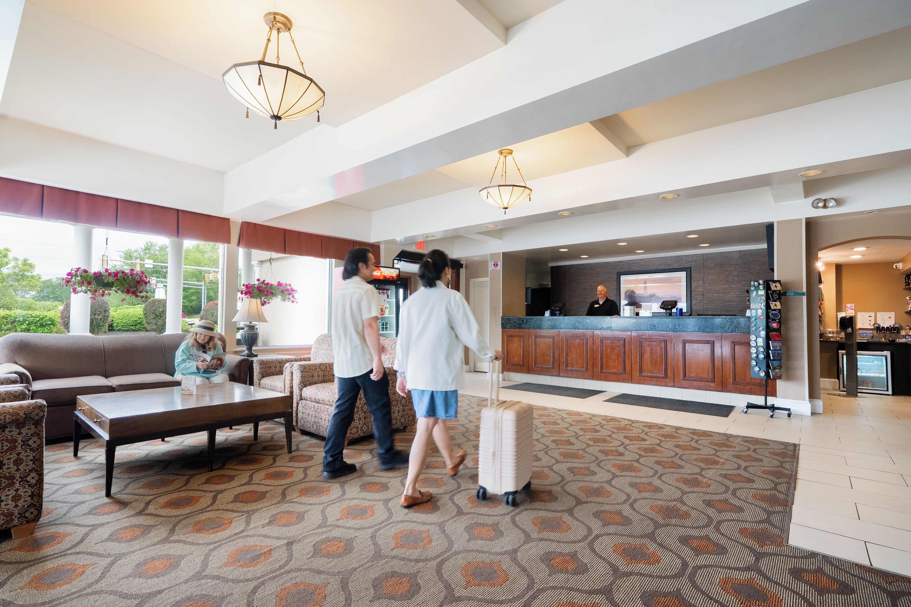 A spacious lobby with a large seating area, a reception desk, and a view of the outdoors.