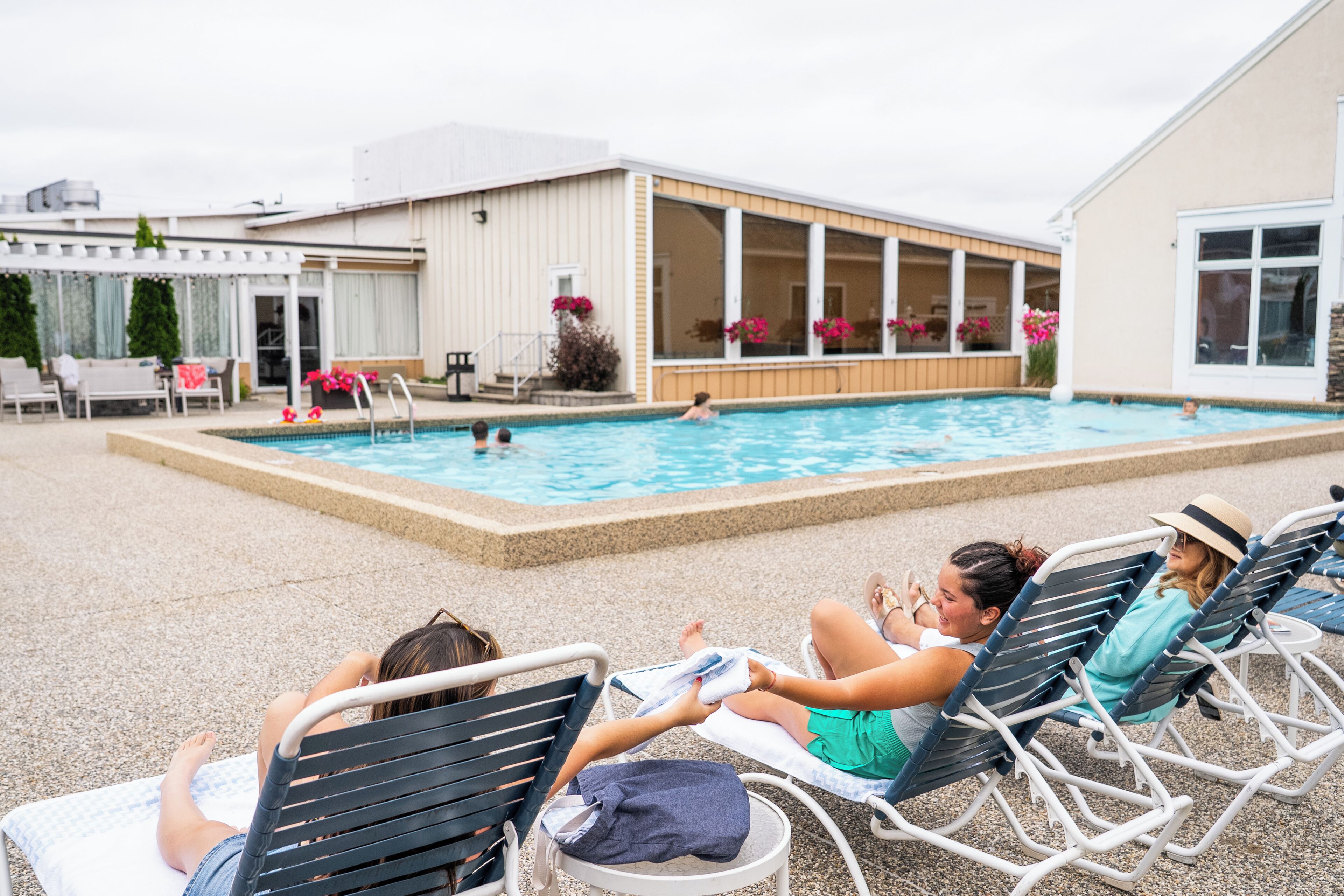 A poolside area with lounge chairs and a pool.