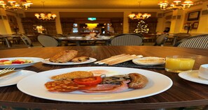 Frukost serveras, med utsikt mot trädgården 