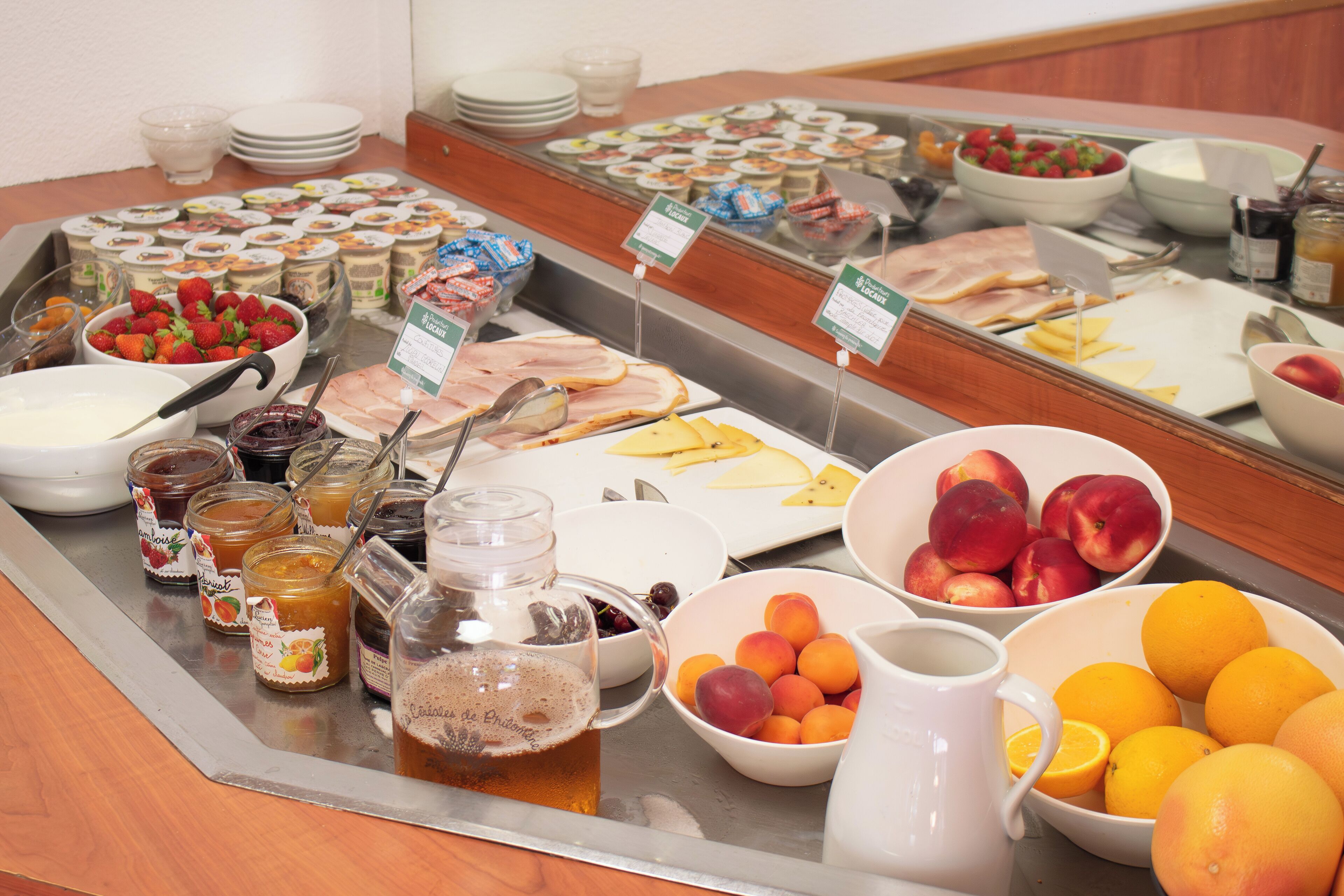 A buffet with various food items including fruits, cheeses, and meats.