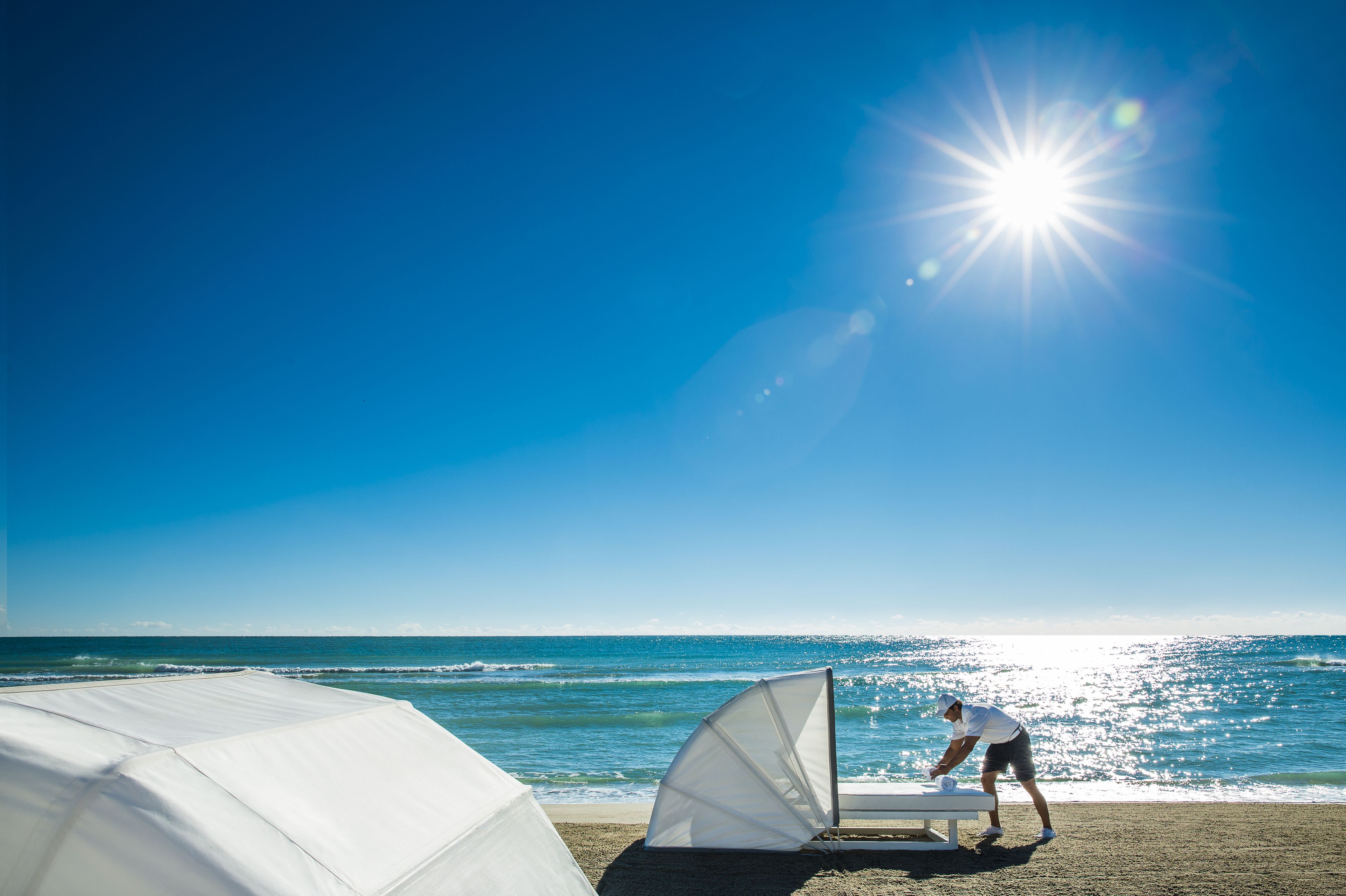 En la playa, camas de playa, sillas reclinables de playa, sombrillas