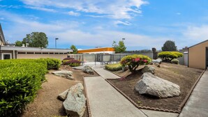 A landscaped outdoor area with pathways, rocks, and trimmed bushes. - Days Inn by Wyndham Mt. Vernon (Mount Vernon)