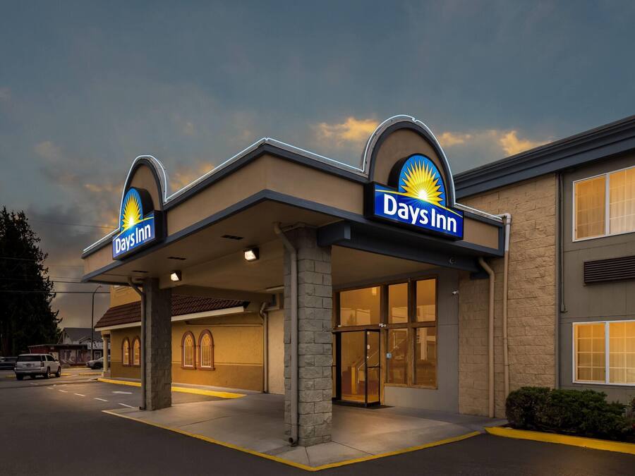 Un Days Inn con entrada despejada, estacionamiento visible y un cartel grande que indica el nombre del hotel.