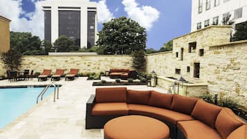 Alberca al aire libre, sombrillas en la alberca y camastros