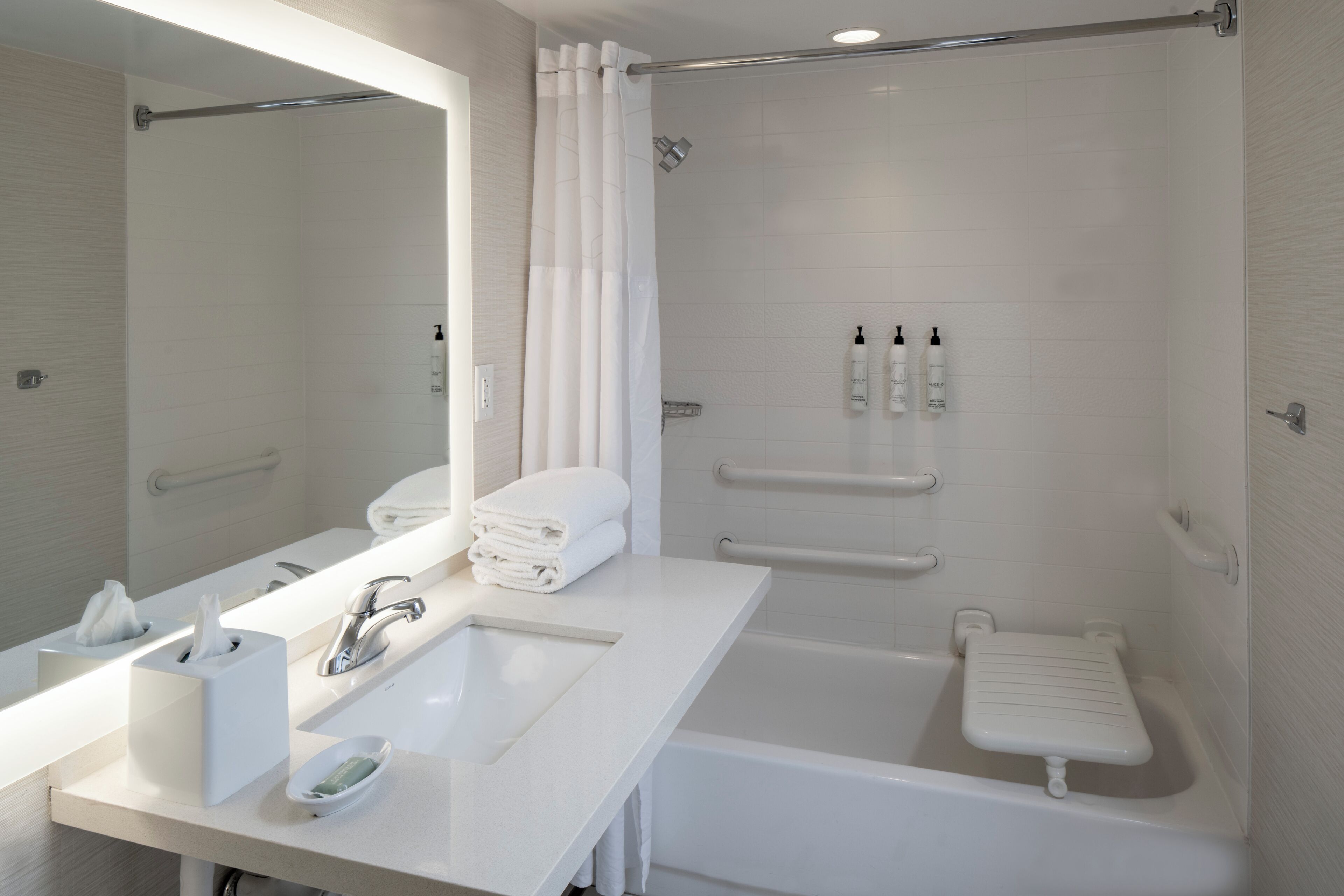Un bagno moderno con un grande specchio, un lavandino, una vasca e una doccia.
