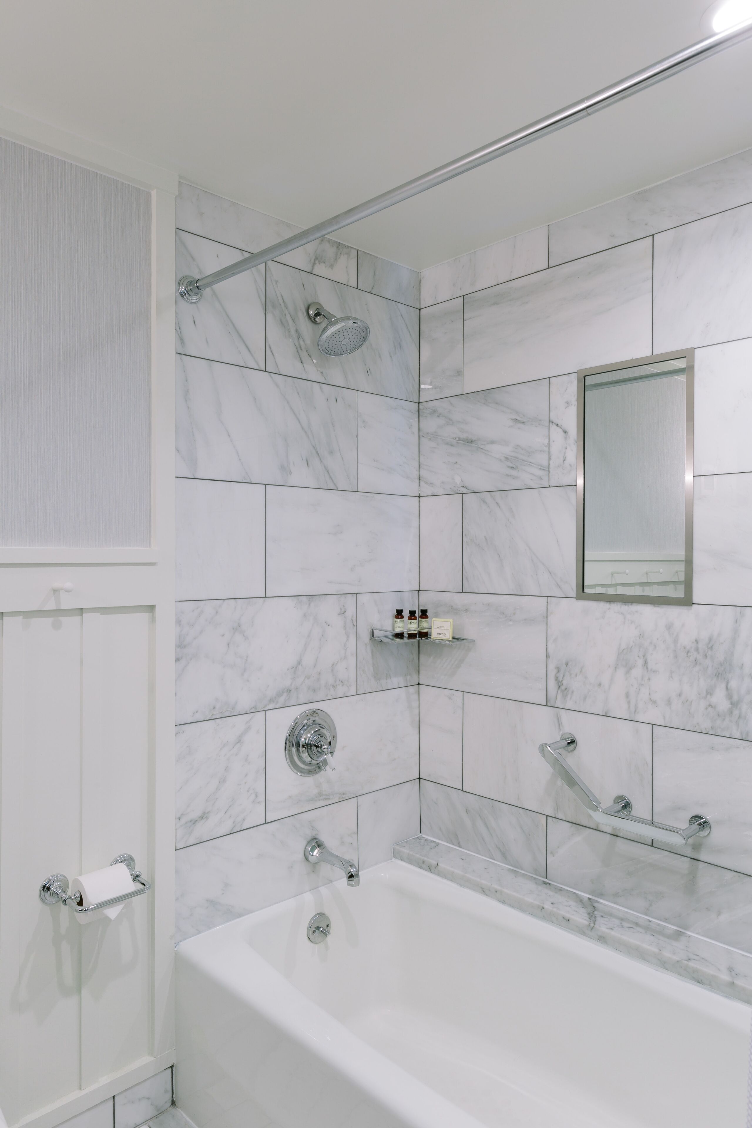 A modern bathroom with a bathtub, a shower, and a toilet.