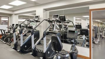 Un gimnasio con cintas de correr, elípticas y máquinas de pesas.