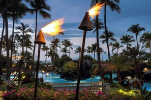 A resort pool area with palm trees, a pool, and a tiki torch. - Marriott's Maui Ocean Club - Lahaina & Napili Towers (Lahaina)