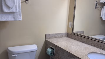 Une salle de bain équipée de toilettes, d’un lavabo et d’un porte-serviettes.