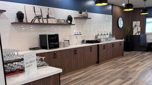 A modern breakfast buffet area with a sign indicating it is open every Saturday and Sunday from 7 am to 11 am. - Ramada by Wyndham London (London)