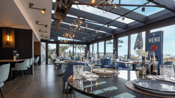 A restaurant with a modern interior, large windows, and a view of the city. - Fletcher Hotel-Restaurant Loosdrecht - Amsterdam (Loosdrecht)