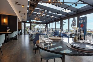 A restaurant with a modern interior, large windows, and a view of the city. - Fletcher Hotel-Restaurant Loosdrecht - Amsterdam (Loosdrecht)