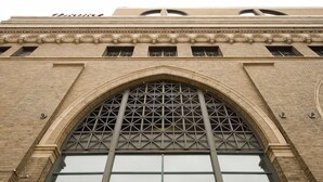 Un bâtiment doté d’une grande fenêtre en arc de cercle et d’un motif quadrillé sur la fenêtre.