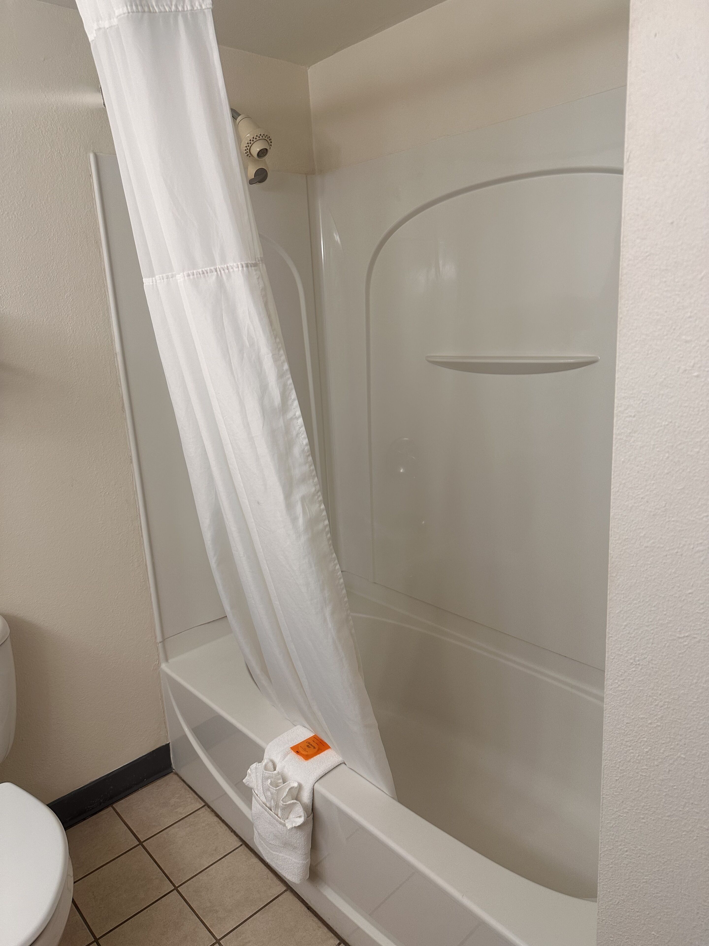Ein Badezimmer mit Badewanne, Toilette und Duschvorhang.