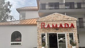Een gebouw met een bordje met de tekst 'RAMADA' boven de ingang.
