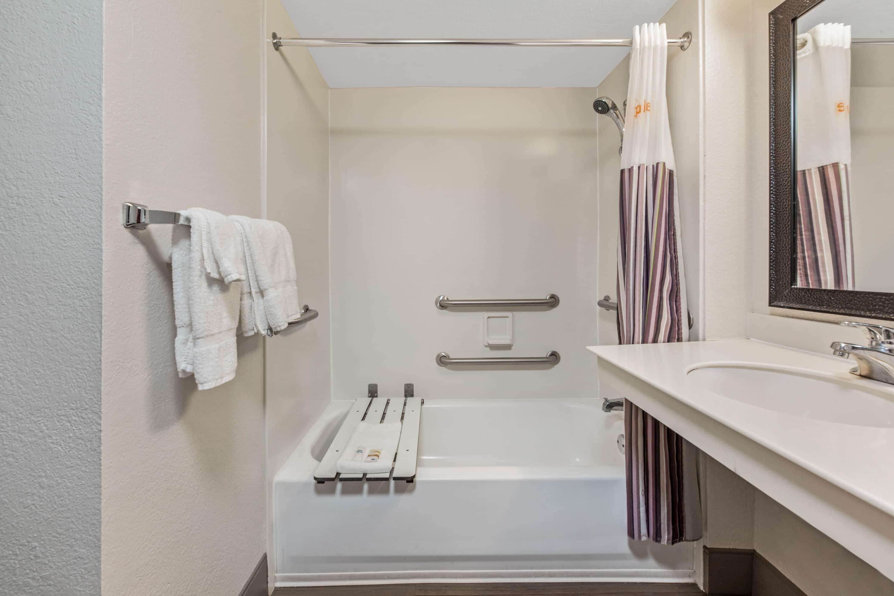 Een moderne badkamer met een bad, een douche, een wastafel en een spiegel.
