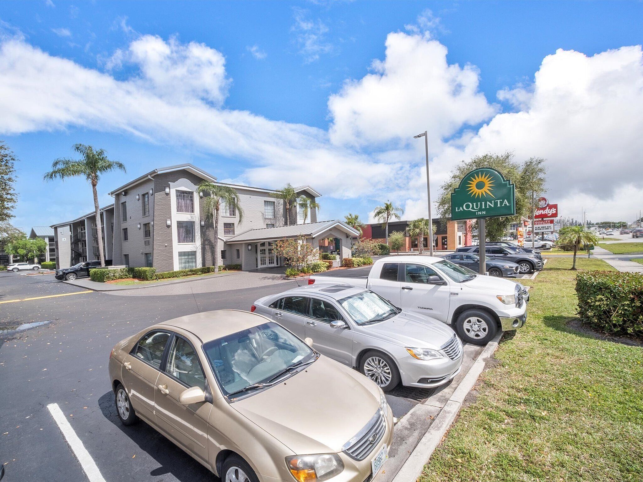 A hotel with a parking lot, a La Quinta Inn sign, and a Wendy's fast-food restaurant in the background.