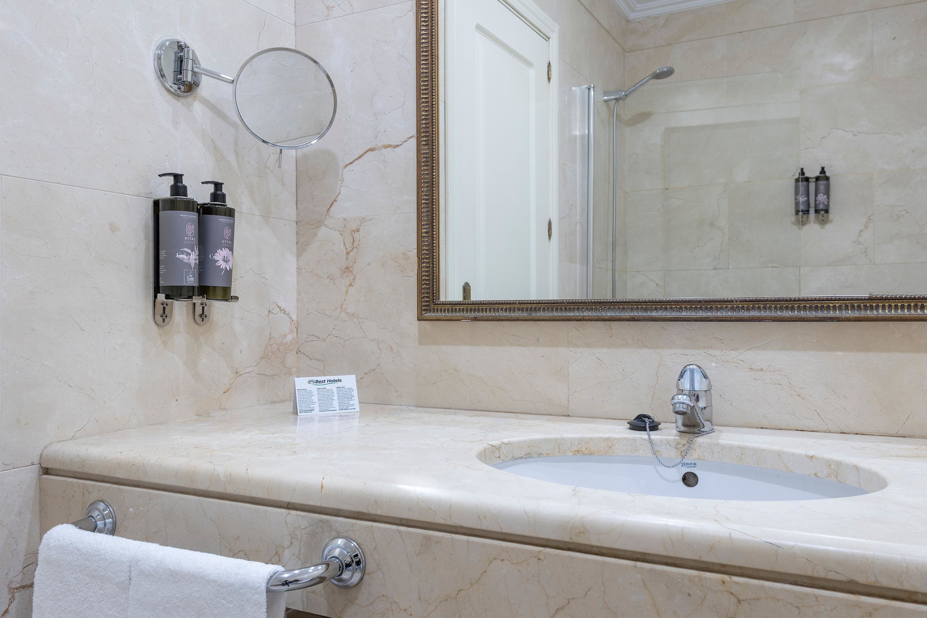 Un bany amb un lavabo de marbre, un mirall i productes de tocador.