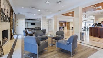 Un hall d’entrée moderne doté d’une cheminée, d’un espace salon et d’un comptoir d’accueil.