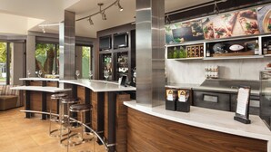 Un área de bar moderna con taburetes altos, una barra y una vitrina de vinos.