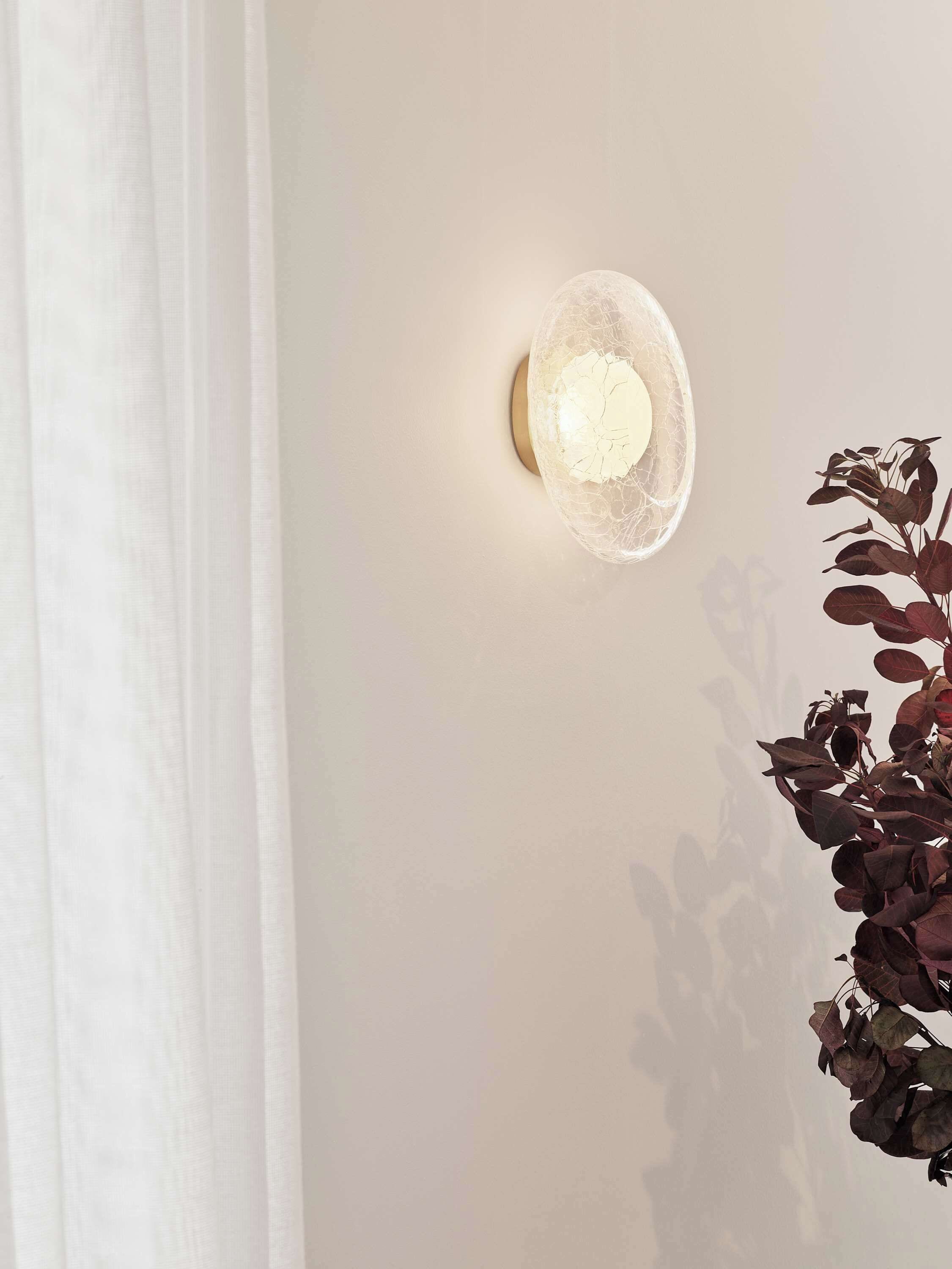 A wall-mounted light fixture with a cracked glass design.