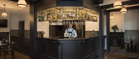 A bar area with a bartender, a wine rack, and a seating area with tables and chairs.