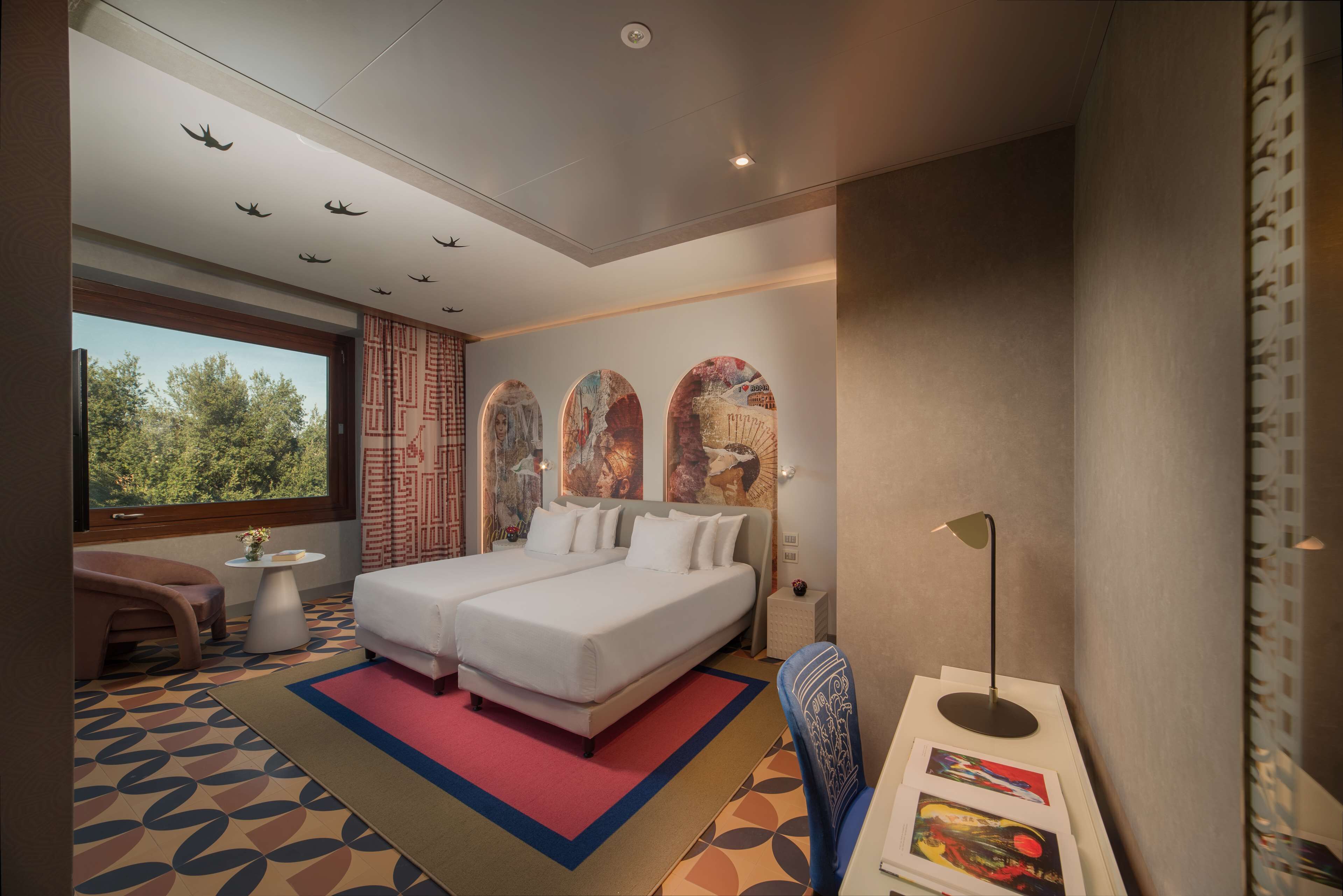 Una habitación de hotel moderna con una cama grande, un escritorio, una silla y una ventana con vistas a árboles.