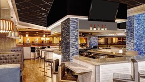 A modern bar area with a counter, seating, and a television screen. - Marriott Lexington Griffin Gate Golf Resort & Spa (Lexington)