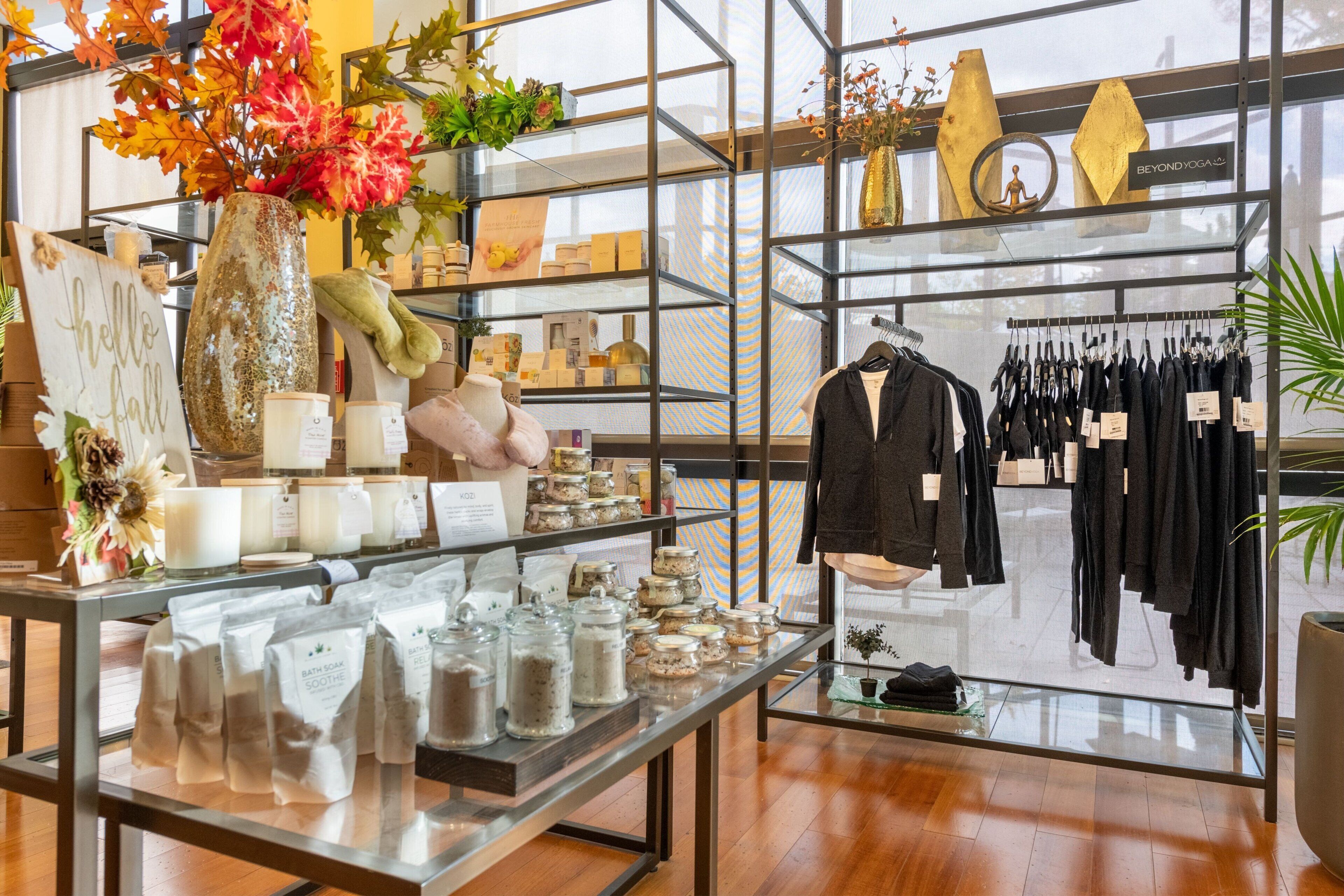Een winkel met schappen vol verzorgingsproducten, een etalage met kleding en decoratieve items.