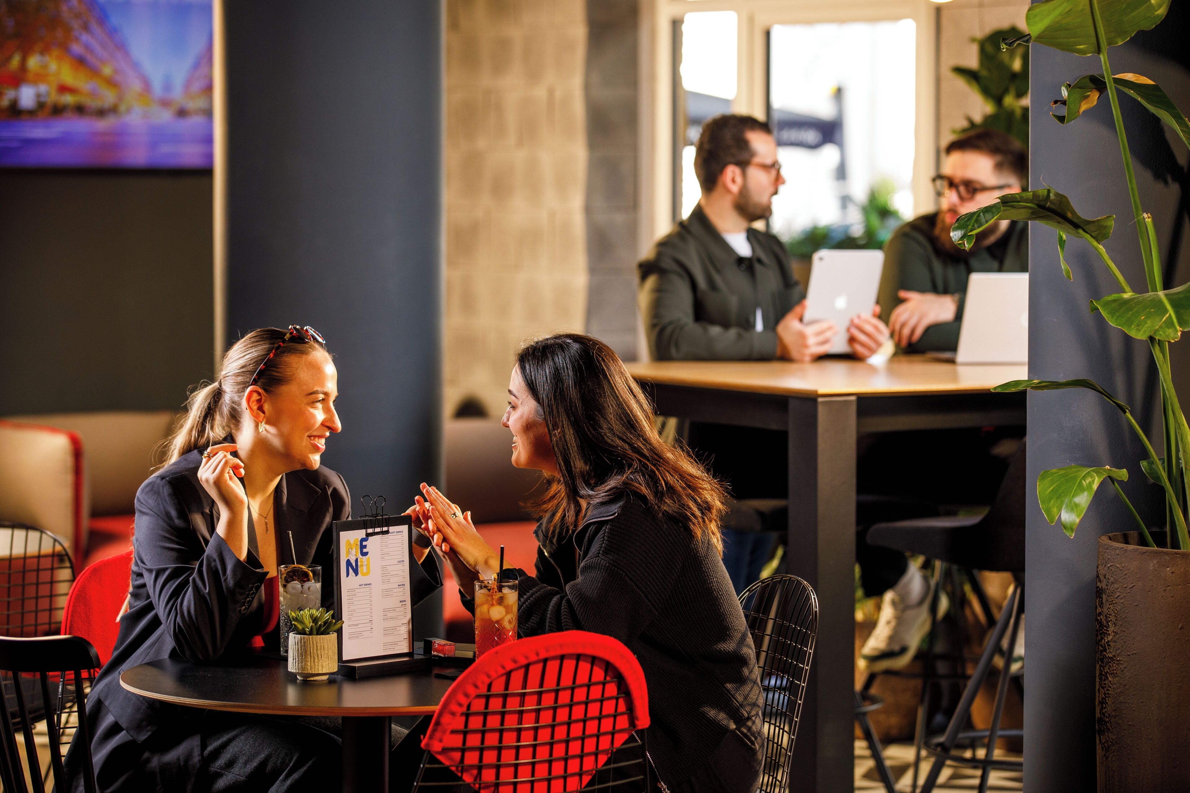 A restaurant with tables, chairs, and a menu.
