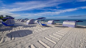 A beach with striped beach umbrellas and lounge chairs. - Naples Grande Beach Resort (Naples)