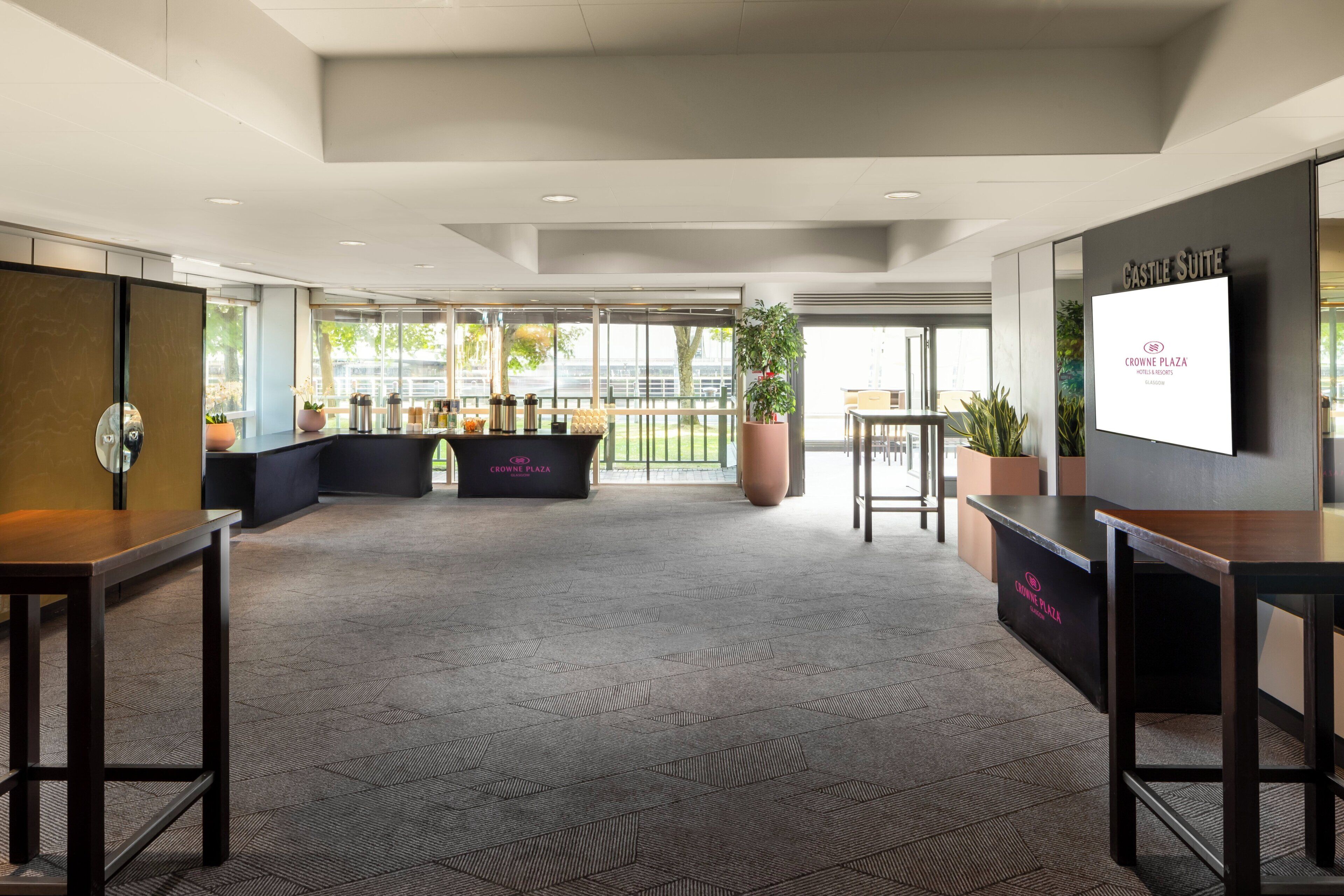 Un hall espacioso con mostrador de recepción, zona de estar y amplias ventanas con vistas al exterior.