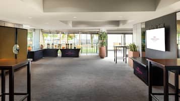 Un hall espacioso con mostrador de recepción, zona de estar y amplias ventanas con vistas al exterior.