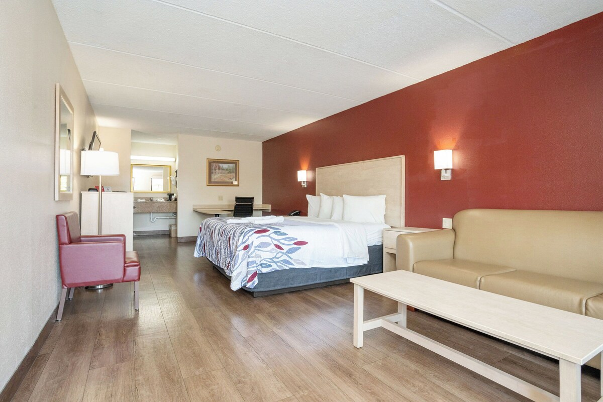 Una habitación de hotel con cama, sofá, escritorio y silla.