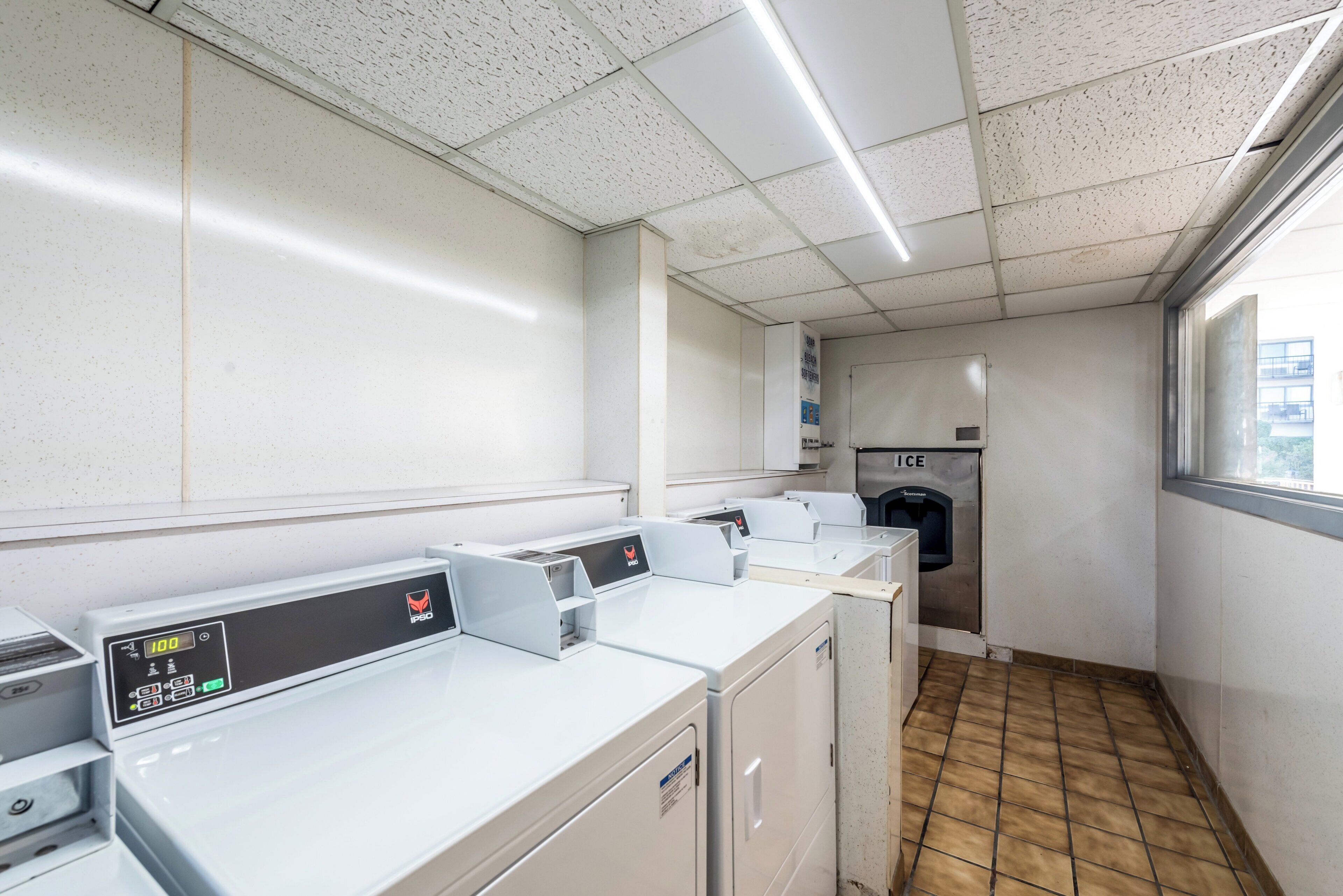 A laundry facility with multiple washing machines, a water softener unit, and a water heater.