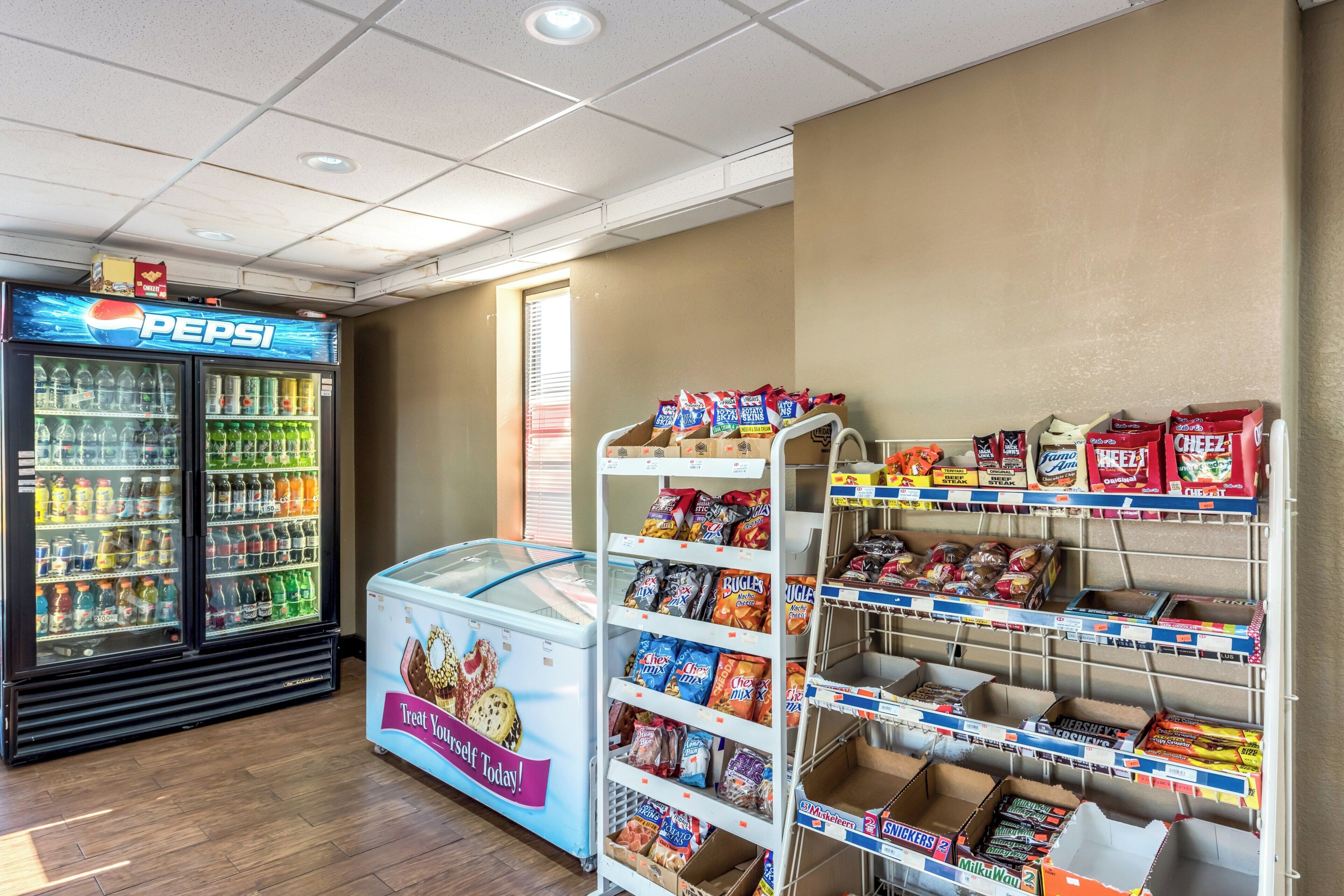 A snack and beverage vending area with a Pepsi cooler and a freezer.