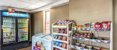 Zona de venta automática con refrigerios y bebidas, incluye un refrigerador de Pepsi y un congelador.